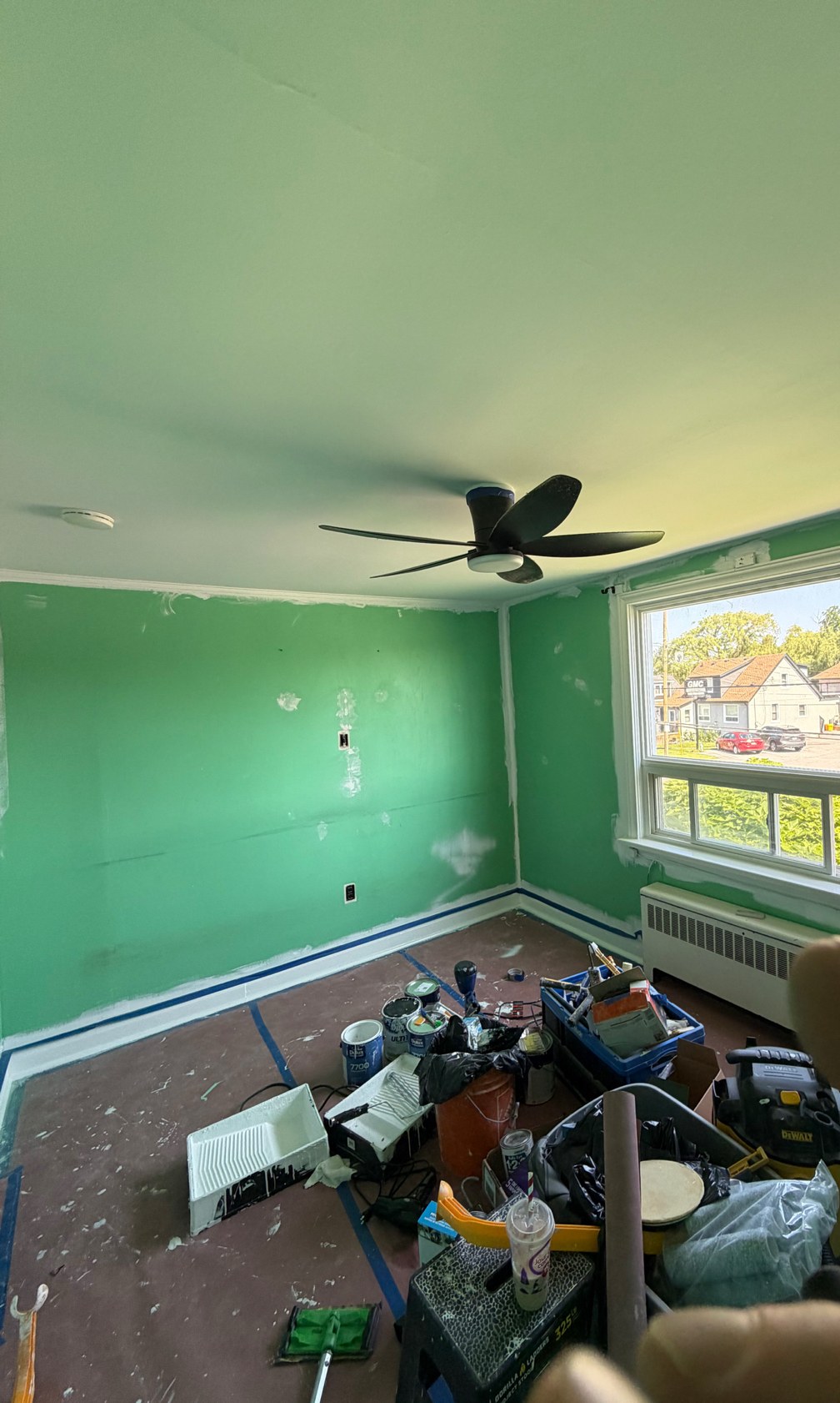 Bedroom before repaint, green walls mid-job